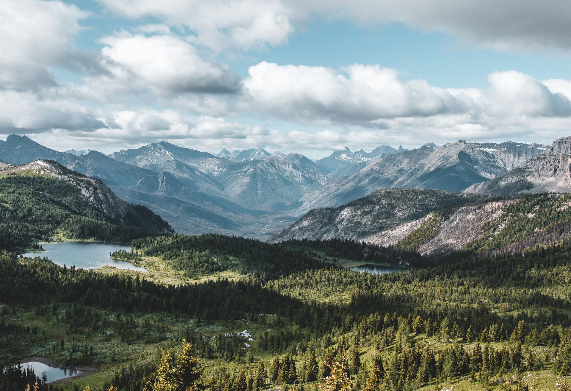 A scenic view of the Rocky Mountains underneath a partially cloudy sky