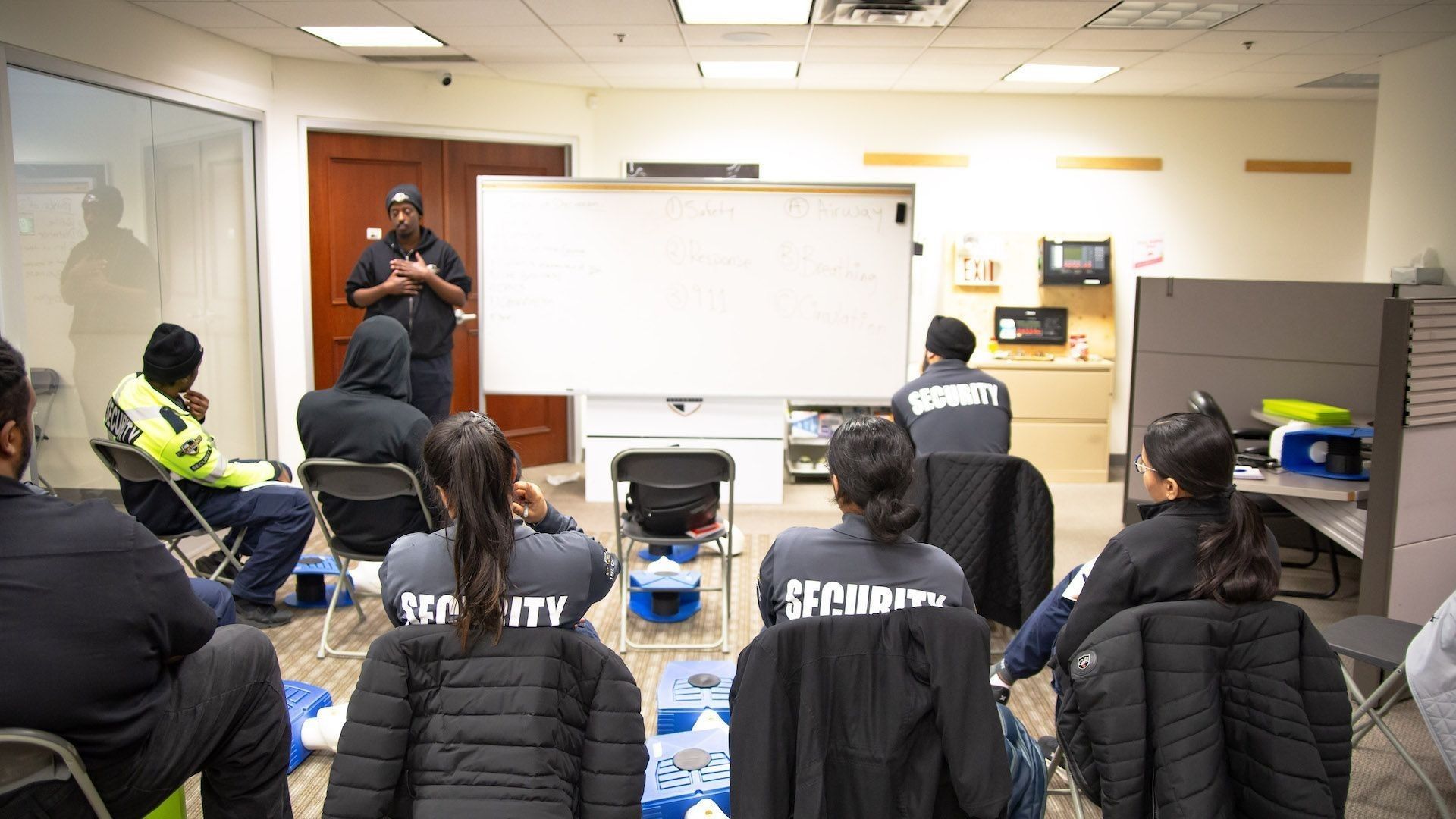 A security guard training class seated and listening to a Flex Point Academy instructor