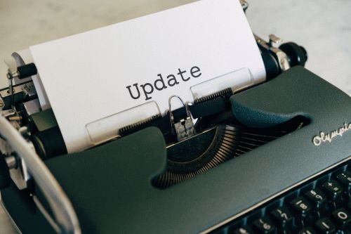 Close up of a typewriter with a paper coming out of it that reads "Update"