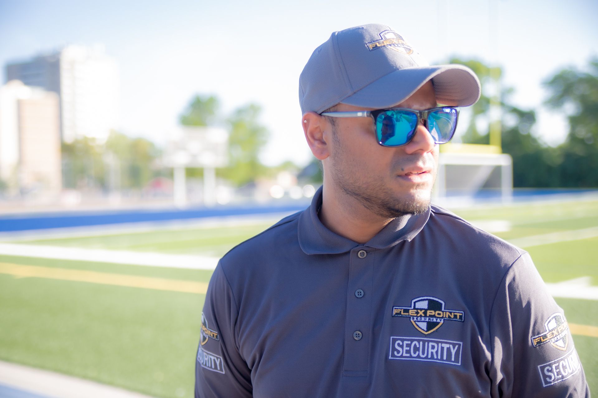 A male Flex Point Security guard standing next to a soccer field while providing security services at an event