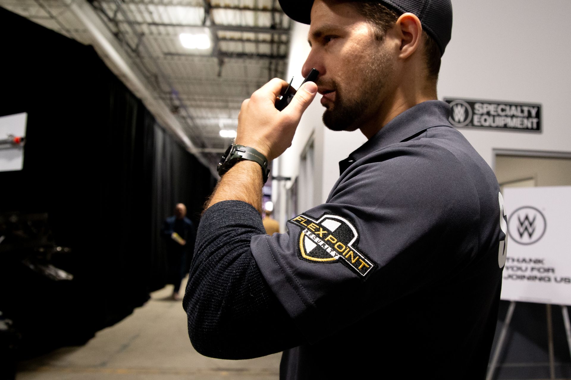 A male Flex Point Security guard interacting with an employee next to a set of stairs in a corporate office