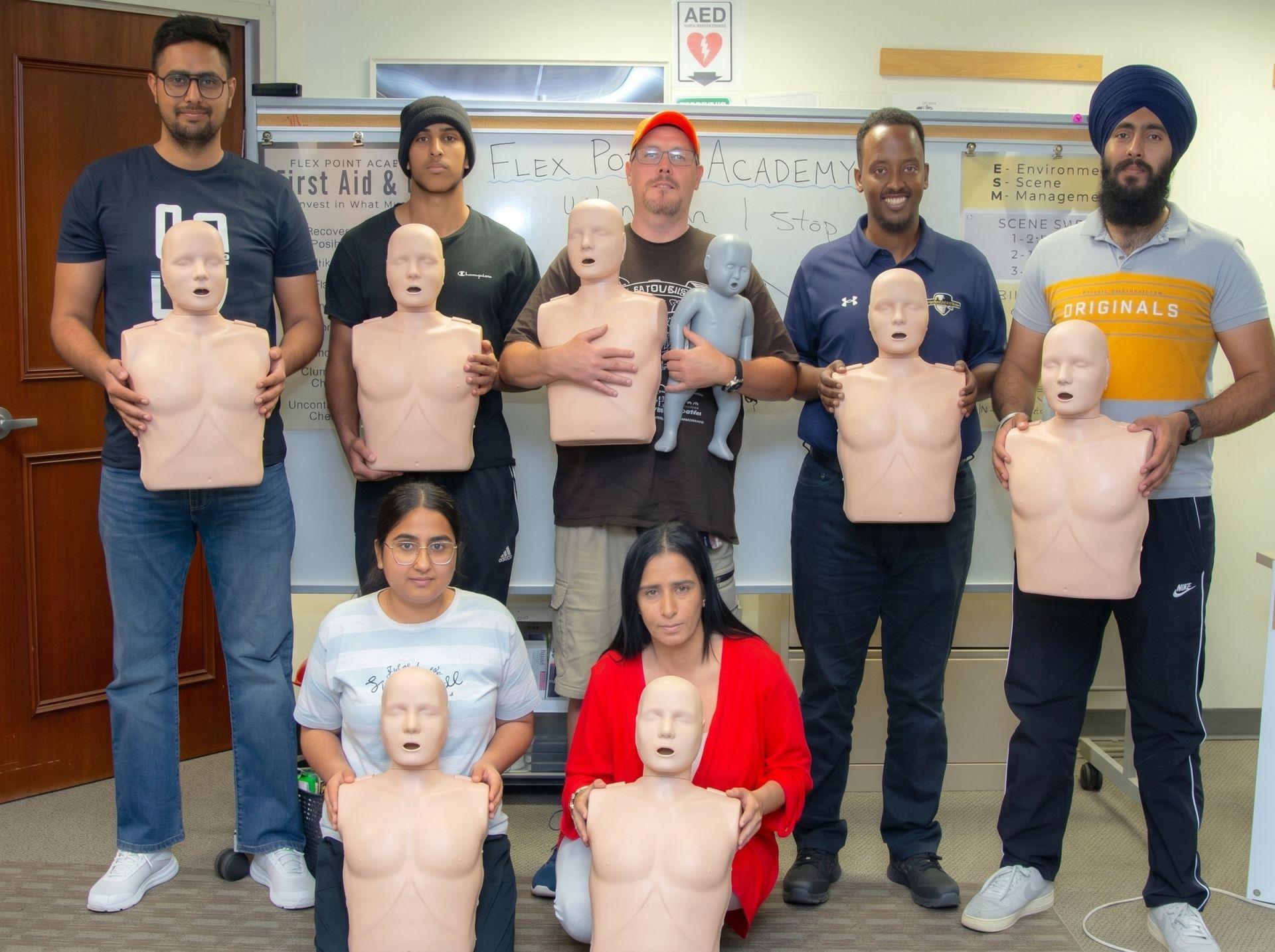 4 Flex Point Academy First Aid & CPR trainees standing next to an instructor upon completion of their training
