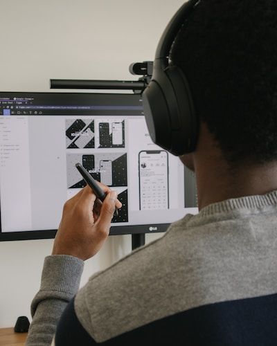 Man working on mobile designs wearing headphones