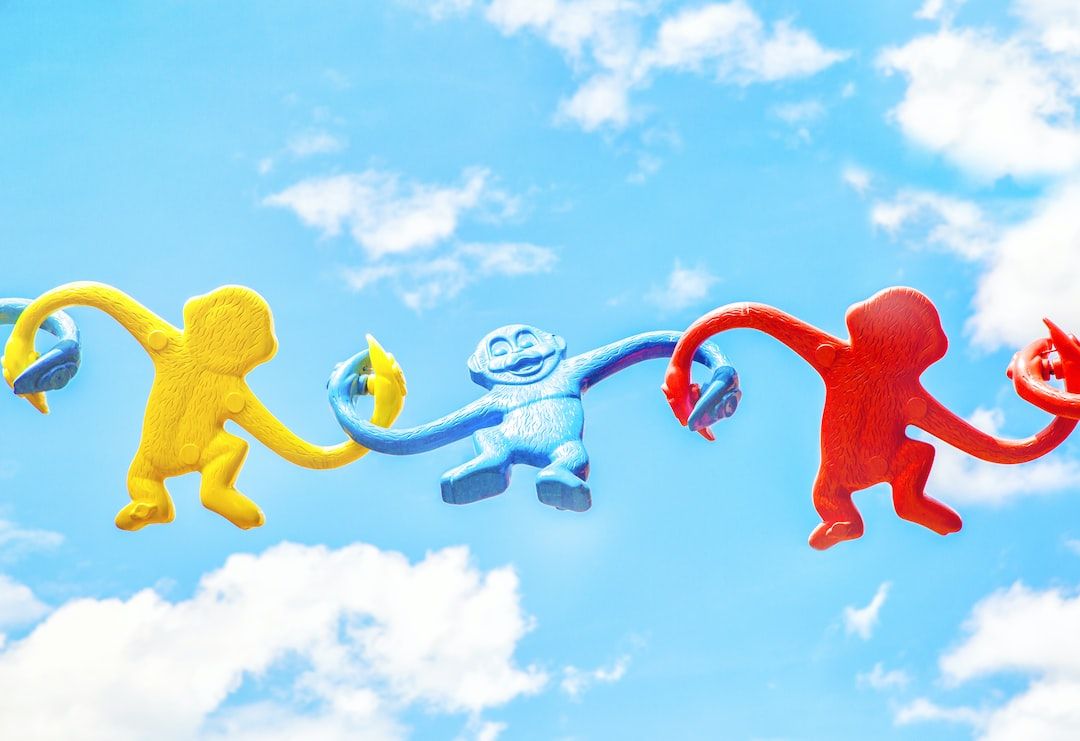 Plastic monkey's swinging on a blue sky background