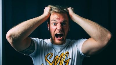 Man screaming with head in hands