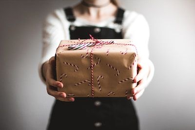 Woman holding out a neatly wrapped gift
