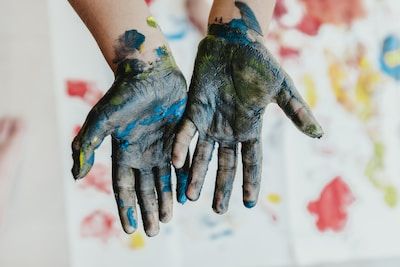 Hands open covered in paint