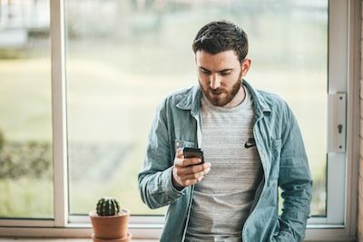 Man wearing blue shirt on mobile phone