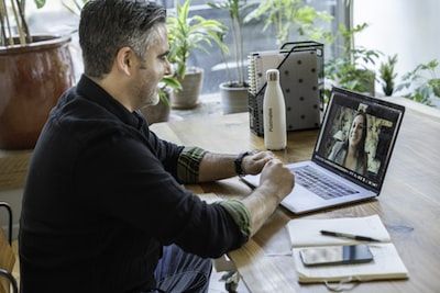 Man sitting at laptop talking to a woman on a video call