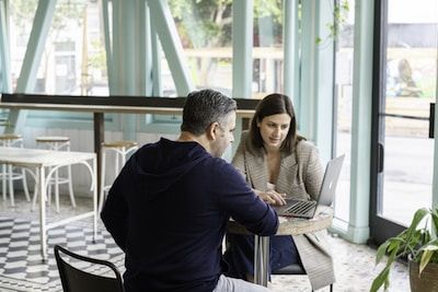 Woman presenting to man on laptop