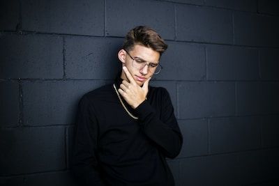 Man thinking leaning against a wall