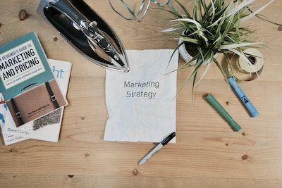 Piece of crumpled paper on a desk with the words marketing strategy printed on it