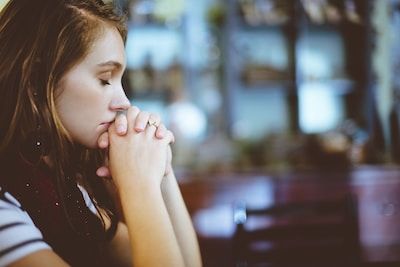 Woman sitting at laptop with eyes closed