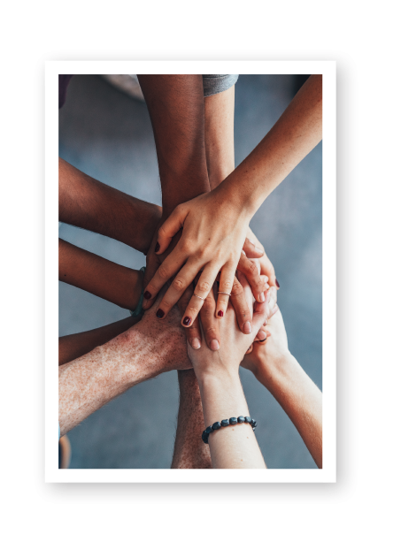 A team of hands collected together in a group clasp