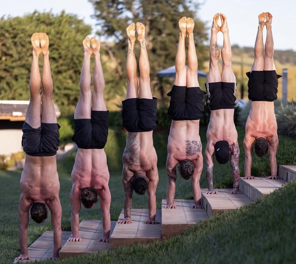 A line of students in handstands at an AoH retreat