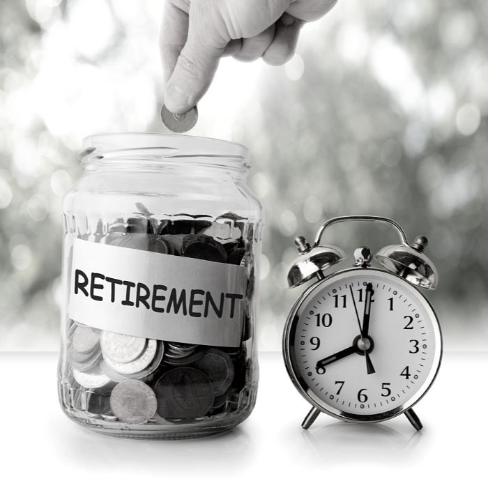Coins in a retirement savings jar and a clock