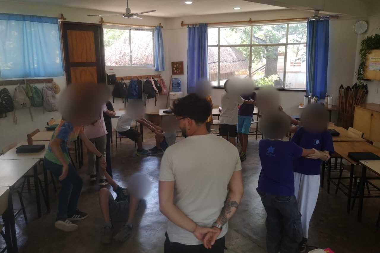 Andrés observa de espaldas un ejercicio de movimiento de estudiantes en una sala de clases.