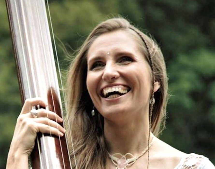 Krishangi Lila laughing while holding a tanpura