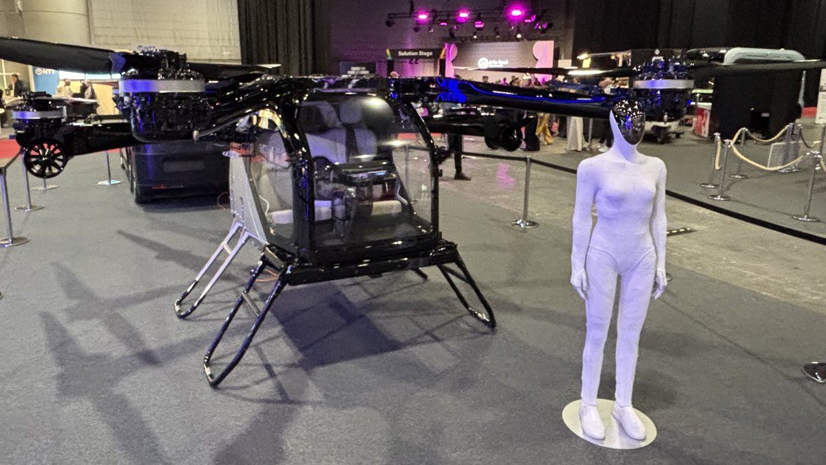 Air taxi drone with white humanoid robot beside it