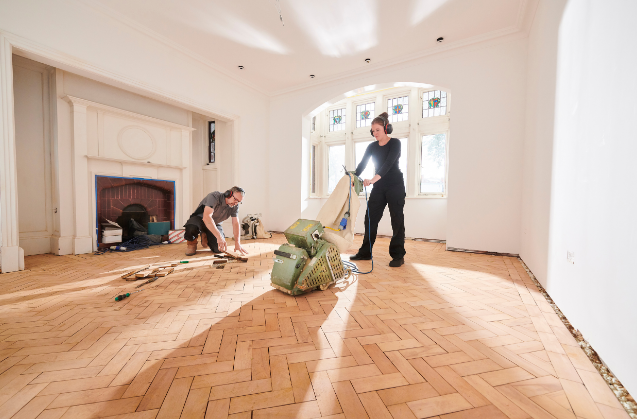 Travaux de rénovation intérieure : équipe de spécialistes restaurant un parquet classique dans une demeure historique