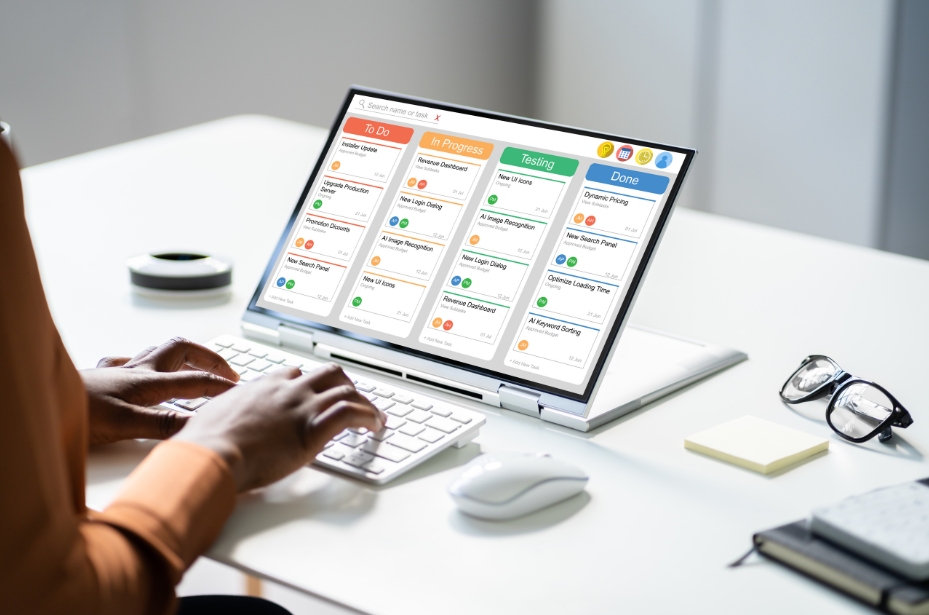 Professional using Kanban project management software on laptop displaying To Do, In Progress, Testing, and Done columns for digital workflow optimization