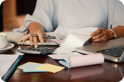 Person kalkuliert Budget mit Taschenrechner