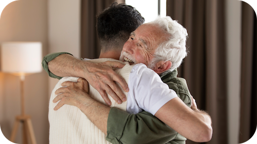 Ein älterer Mann umarmt einen jungen Mann