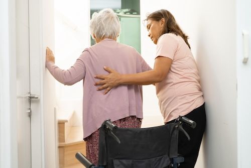 Tochter hilft ihrer Mutter ins Zimmer im Pflegeheim