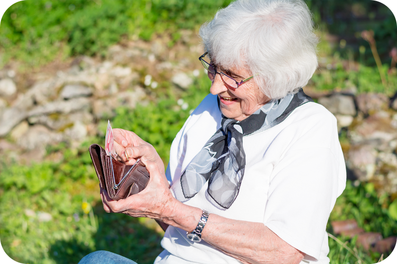 Seniorin übergibt Pflegegeld an pflegende Angehörige