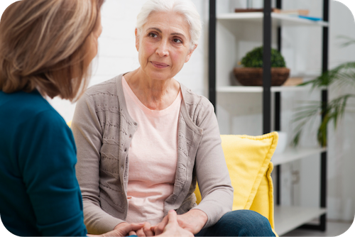 Seniorin sitzt auf einem Sofa während einer Psychotherapie-Sitzung