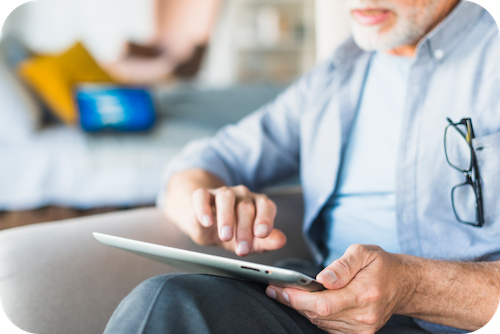 Person nutzt eine App auf einem Tablet als digitale Pflegeanwendung (DiPa)