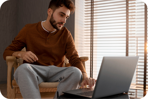 jüngerer Herr informiert sich am Laptop über den Grad der Behinderung