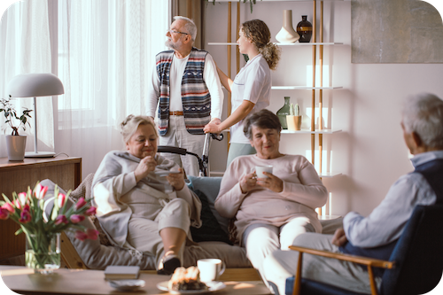 Familie sitzt im Wohnzimmer mit einer Pflegekraft