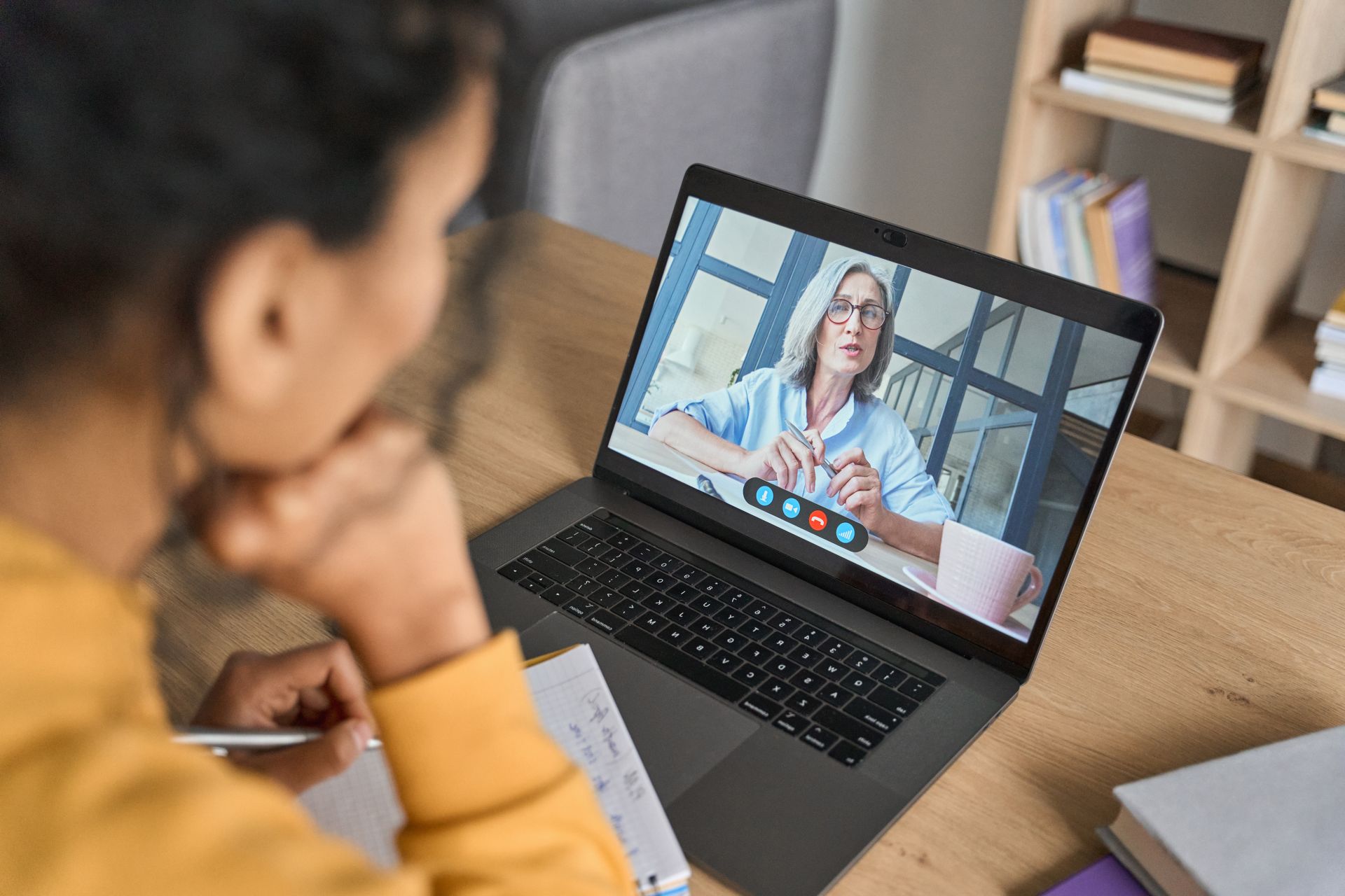 Eine Frau sitzt vor einem Computer auf dem ein Videokurs läuft.