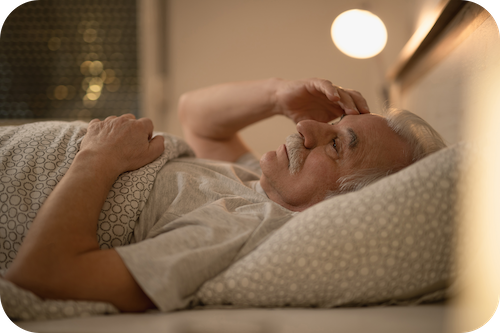 Älterer Mann liegt nachdenkend im Bett