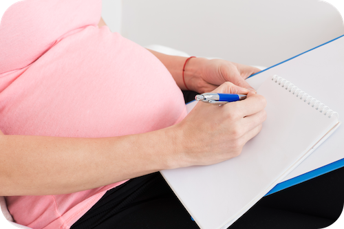 Schwangere Person macht sich Notizen