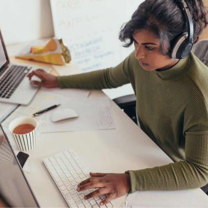 Female programmer coding on desktop computer