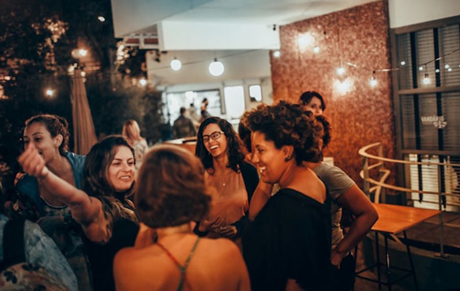Friends laughing in a bar — language immersion through real conversation