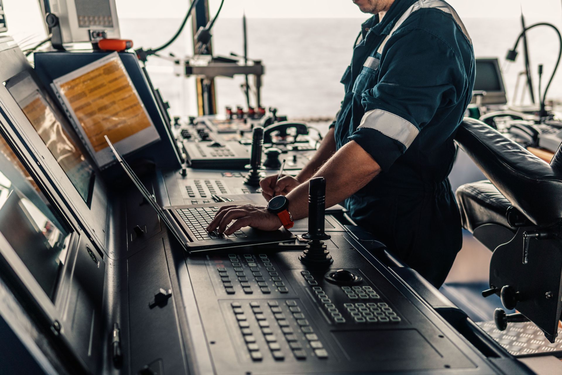 A maritime professional expertly navigating ship operations on a laptop, representing Maritime Trainer's Retain Solutions.