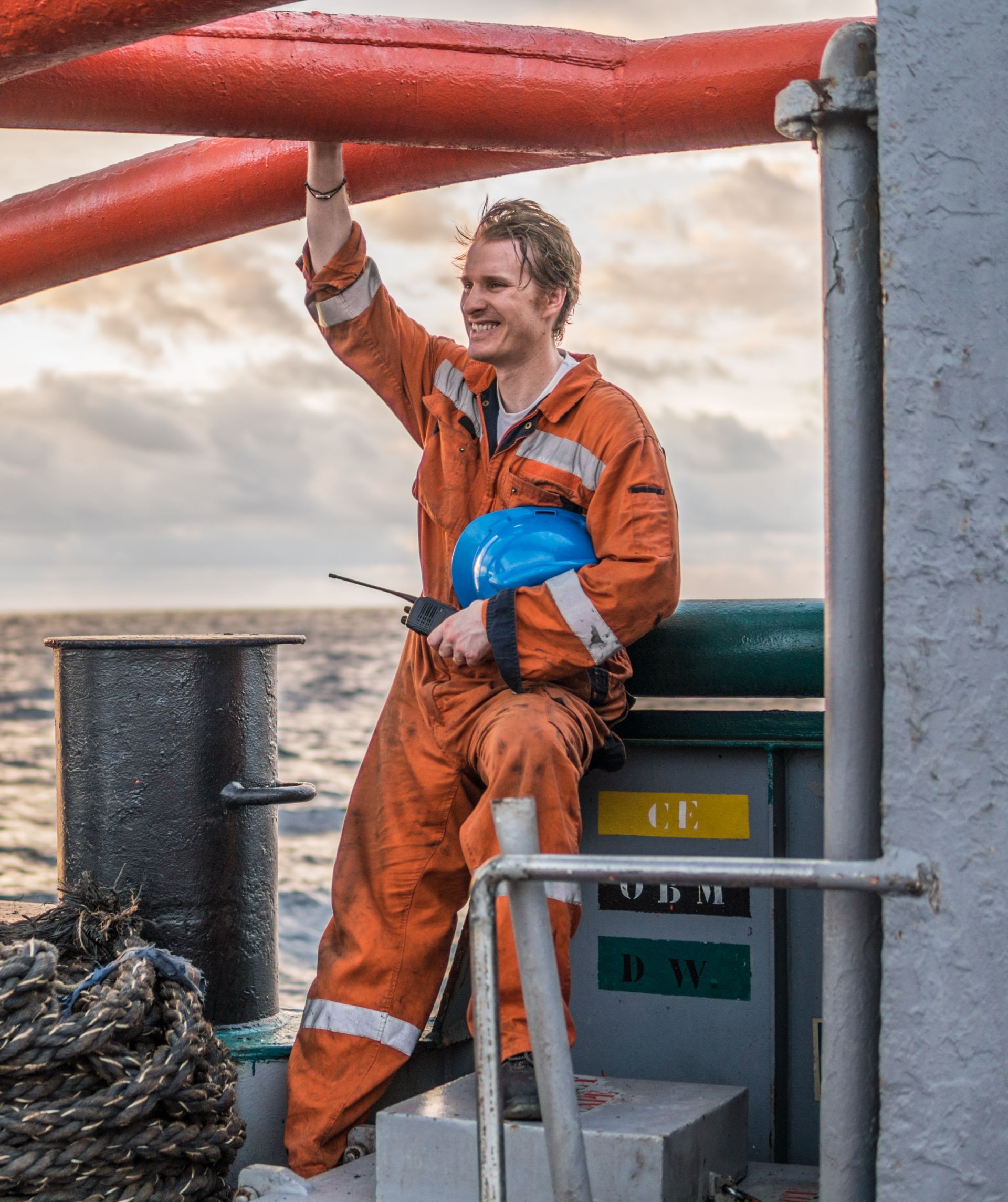 A happy maritime crew member preparing equipment on deck, reflecting the well-being focus of the MTCare Program.