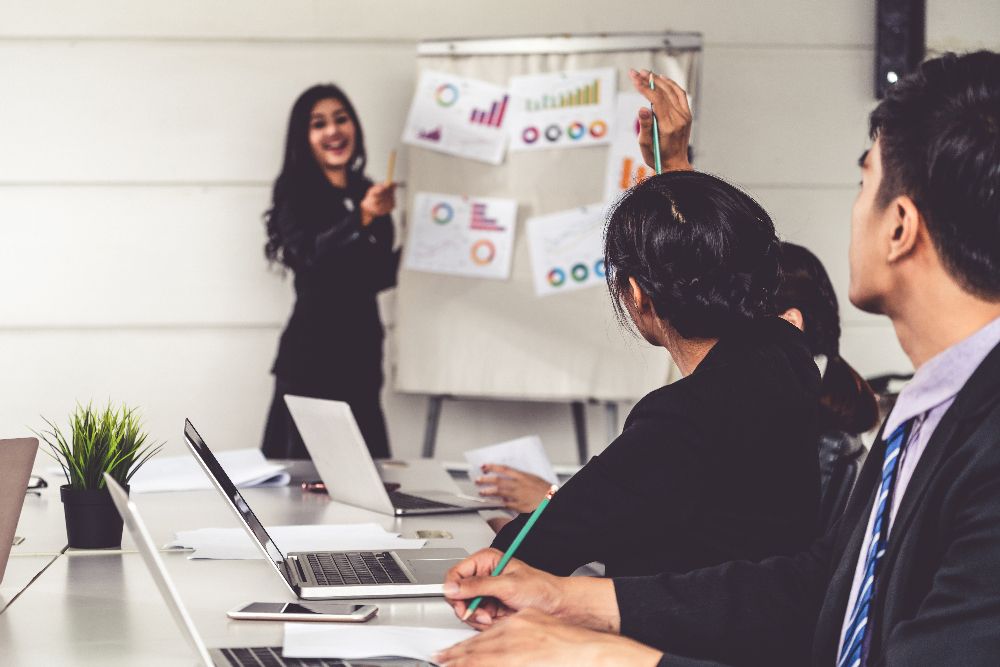 A work team metting, which is one team leader and three group members. The team leader just gave exciting news to the members as they are clapping and happy.