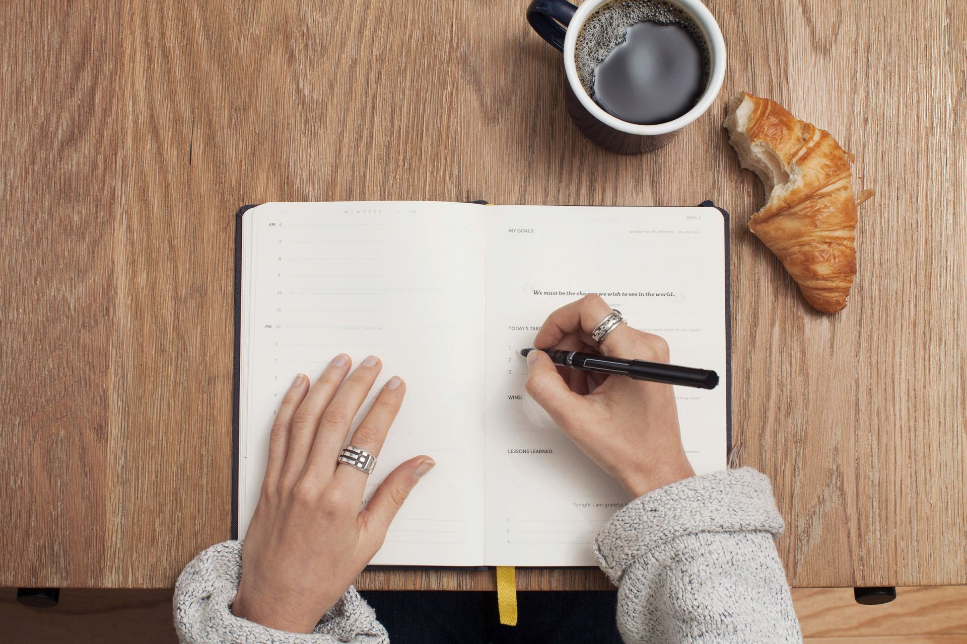 A buisness woman creating a goal plan in her note book.