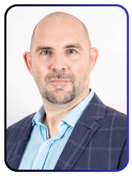 Professional headshot of Dr. Scott Wustenberg, dressed in a blue checked blazer and light blue shirt, with a focused and confident expression.