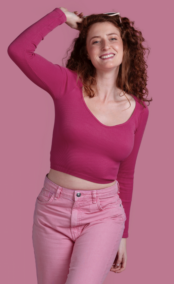 Junge Frau mit birnenförmiger Figur trägt ein schlichtes, selbstgenähtes roséfarbenes Kleid und läuft durch eine ruhige Stadtstraße – Beispiel für typgerechte Kleidung nähen.