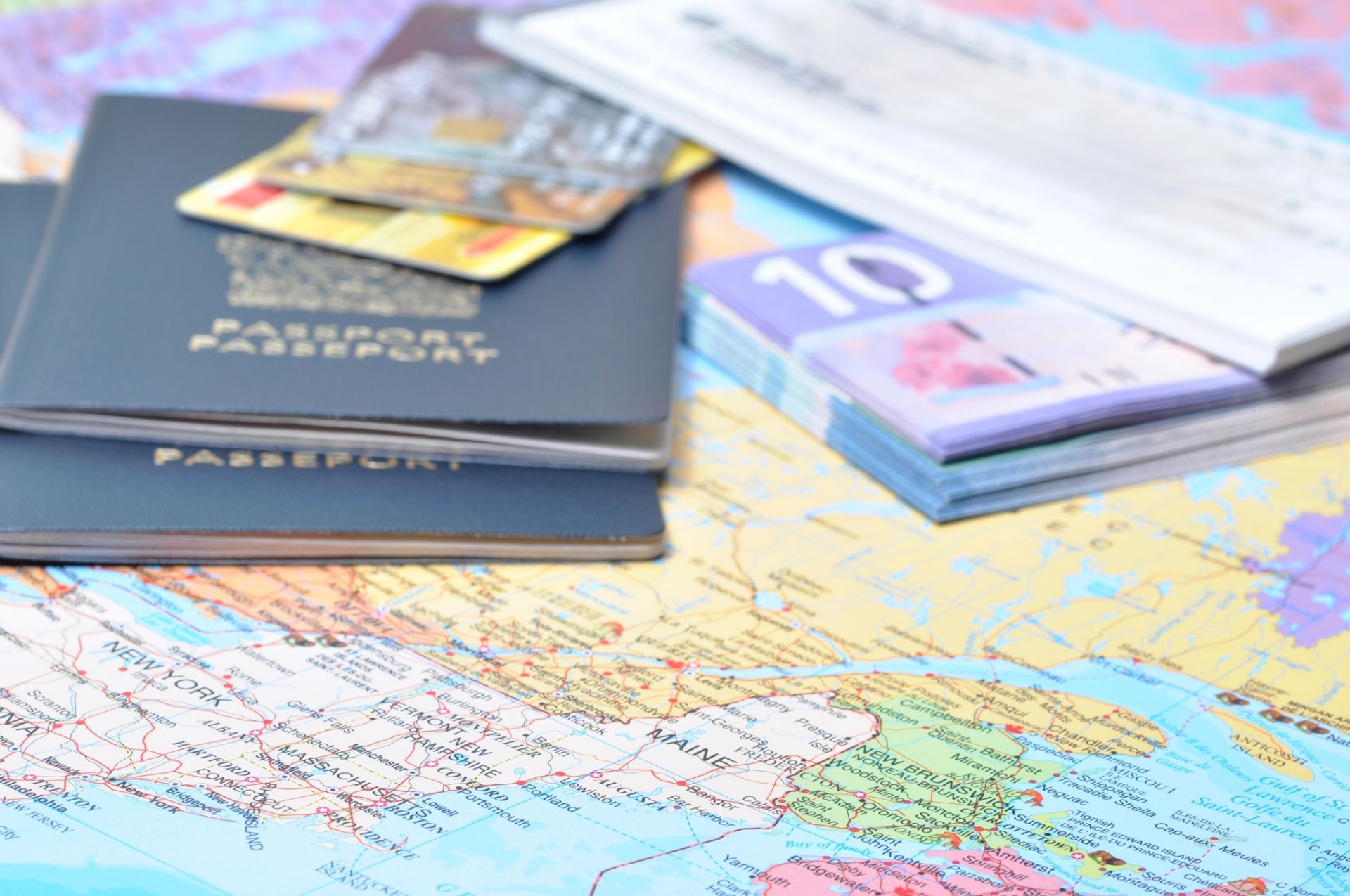 Passports, travel tickets, and international currency placed on a world map — representing global travel preparation and documentation for the U.S. Visa-Bond Navigator Kit.