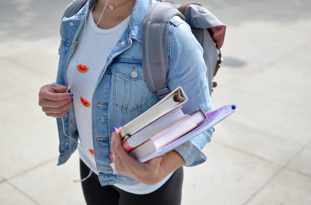 student with backpack holding books