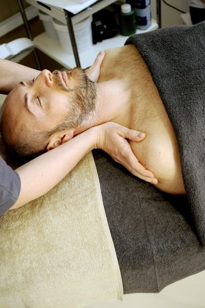 Beauty therapist performing a facial massage on a male client during a spa or skincare treatment