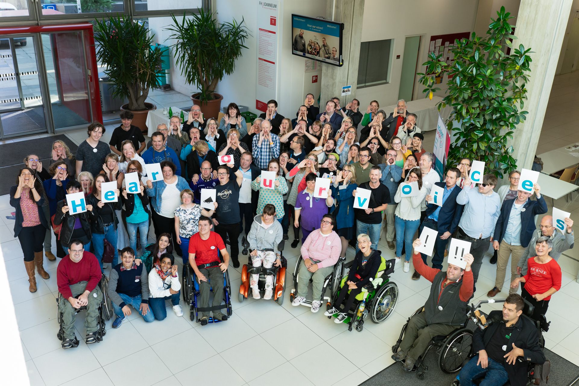 Group of people holding cards that say hear our voices