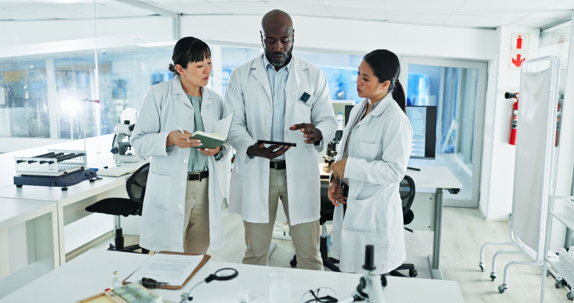 Two lab workers looking at a clipboard and liquid sample
