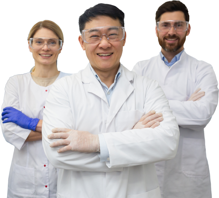 A group of scientists in lab coats and lab glasses smiling with their arms crossed